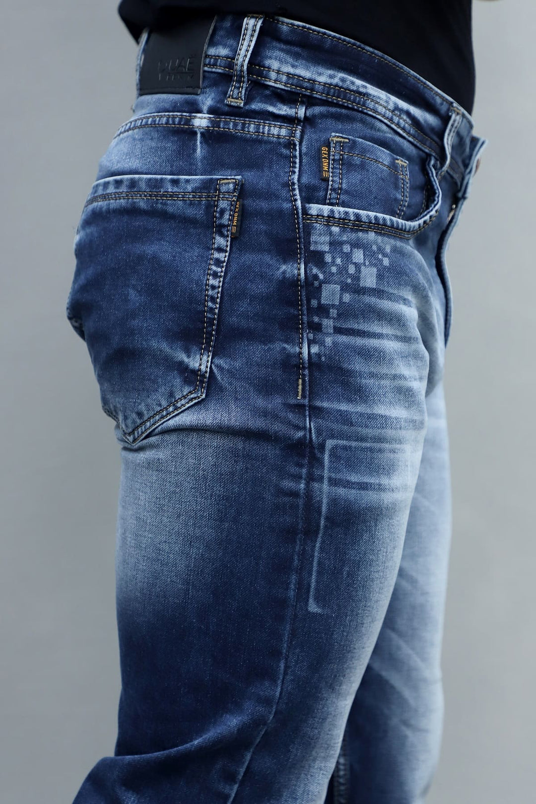 Close up of blue washed stretchable denim fabric in men's slim fit jeans E8