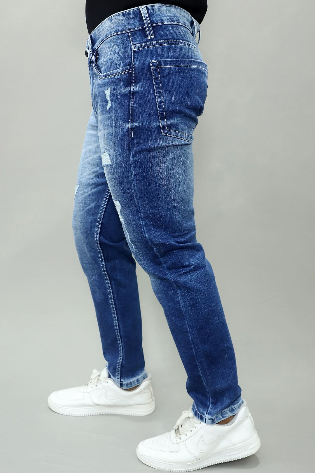 Close up of blue stretch denim fabric in GEX men's slim fit distressed jeans E13